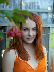 Sexy redhead Shaya lets her bright orange dress slip down to bare her gorgeous breasts